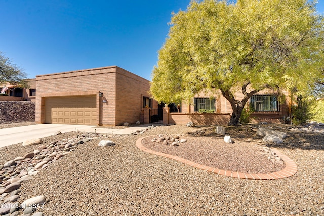 view of front of house with a garage, concrete driveway, and brick siding