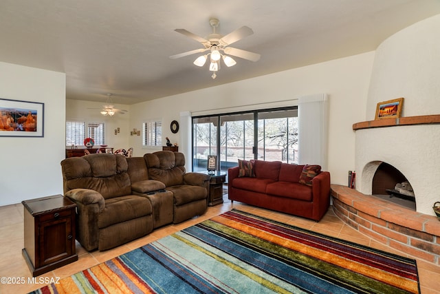 living area featuring ceiling fan and a fireplace