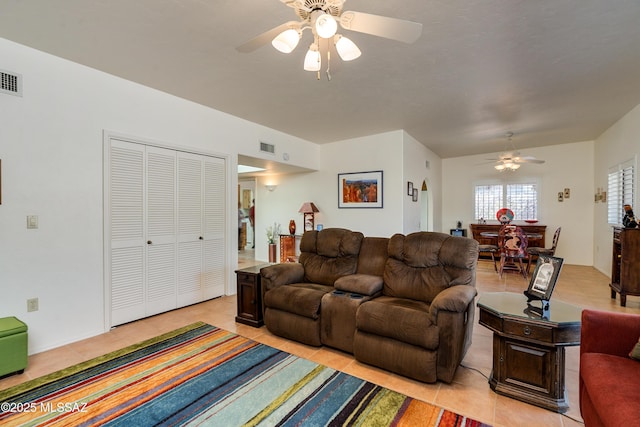 living room featuring light tile patterned flooring, ceiling fan, and visible vents