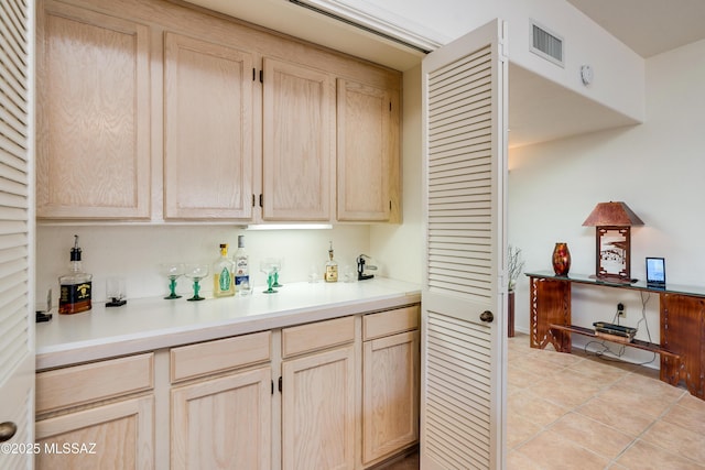 kitchen with light countertops, visible vents, light brown cabinets, and light tile patterned floors