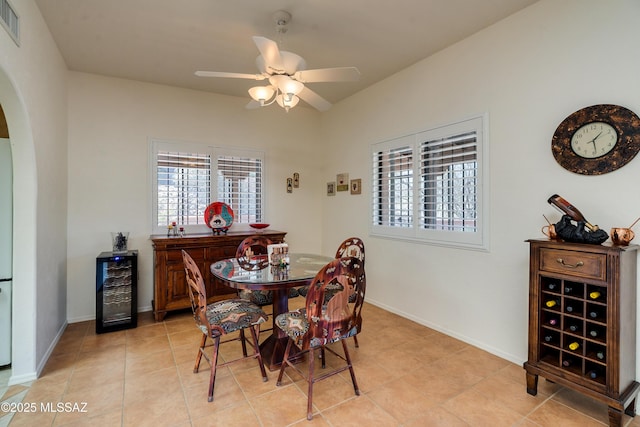 dining space featuring arched walkways, wine cooler, plenty of natural light, and visible vents