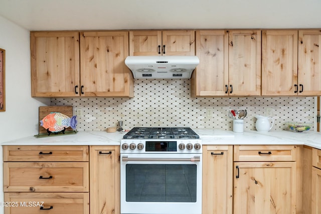 kitchen featuring backsplash, gas stove, light brown cabinets, light stone countertops, and under cabinet range hood