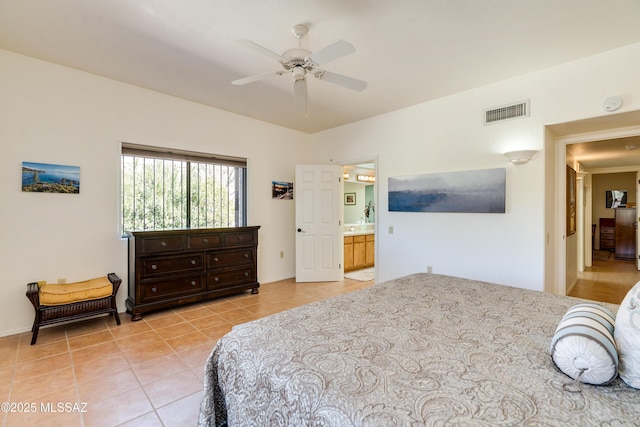 bedroom featuring light tile patterned floors, ensuite bathroom, visible vents, and a ceiling fan