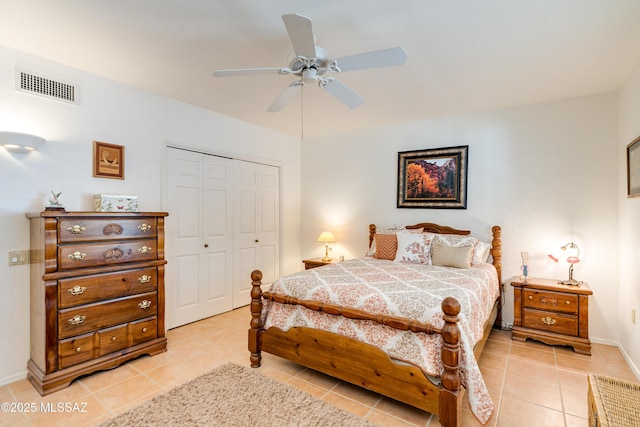 bedroom featuring light tile patterned floors, a closet, visible vents, ceiling fan, and baseboards