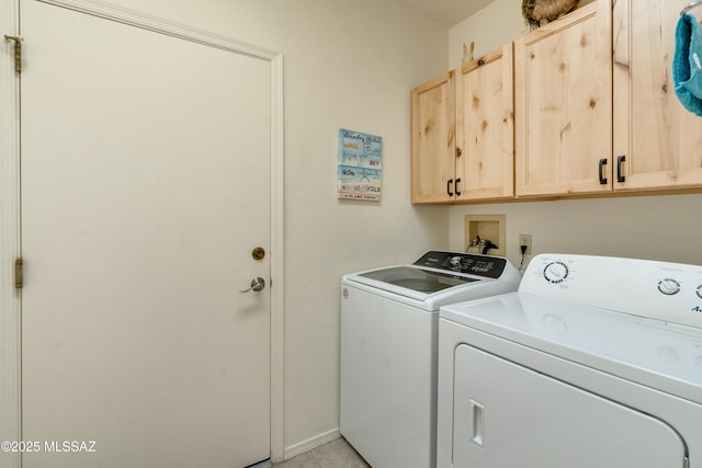 washroom with washing machine and dryer and cabinet space