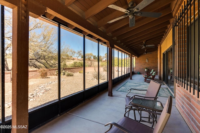 sunroom / solarium featuring lofted ceiling with beams and a ceiling fan