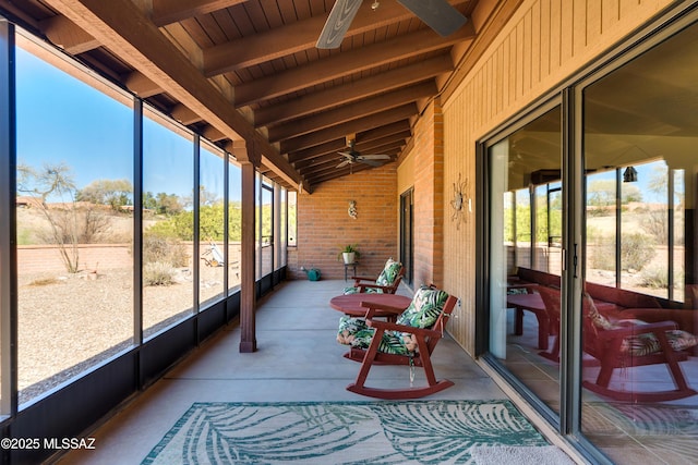 sunroom / solarium featuring a ceiling fan, wooden ceiling, plenty of natural light, and lofted ceiling with beams