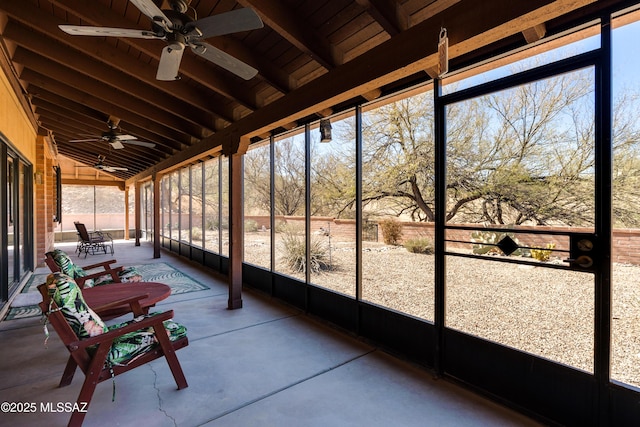 unfurnished sunroom with vaulted ceiling with beams