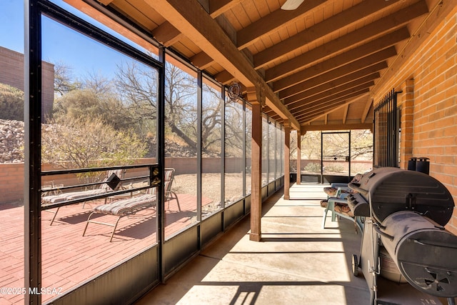 unfurnished sunroom with vaulted ceiling with beams and plenty of natural light