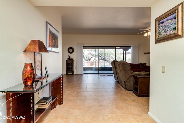 hall featuring light tile patterned floors and baseboards