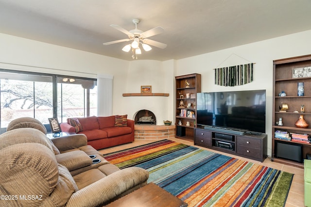 tiled living room featuring a ceiling fan and a brick fireplace