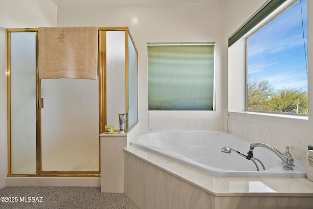 bathroom featuring a shower stall and a bath