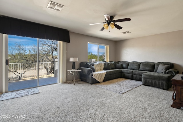 carpeted living area featuring visible vents and ceiling fan