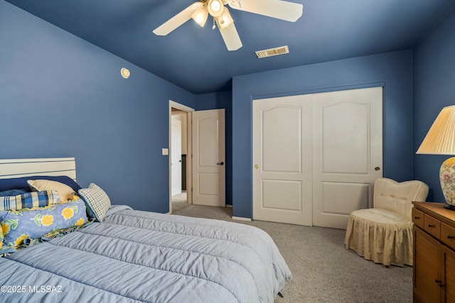 bedroom with light carpet, ceiling fan, visible vents, and a closet