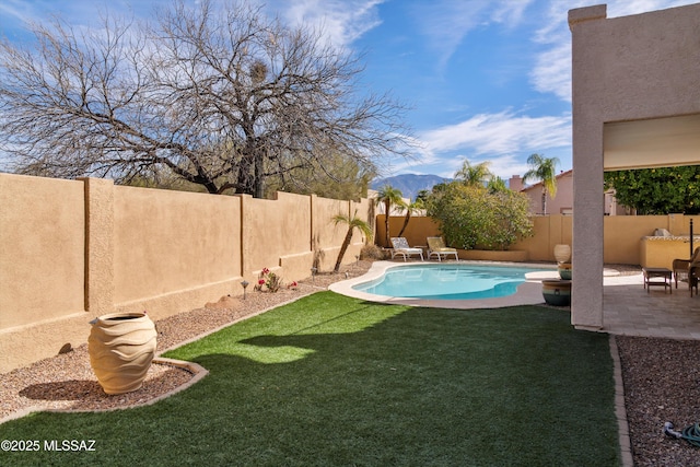 view of pool featuring a lawn, a patio area, a fenced backyard, and a fenced in pool