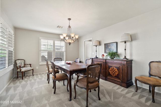 dining space with a notable chandelier, baseboards, visible vents, and light colored carpet