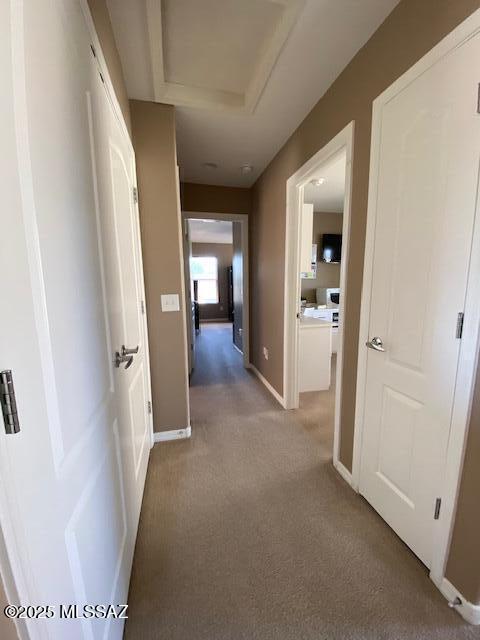 hall with carpet floors and baseboards