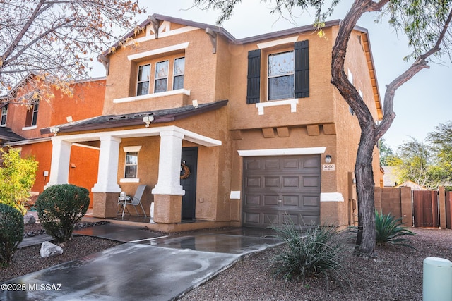 view of front facade with stucco siding, a porch, an attached garage, fence, and driveway