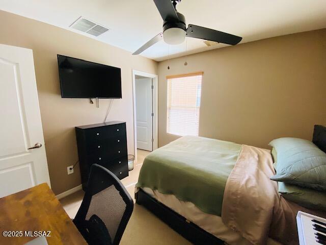 bedroom with baseboards, light colored carpet, visible vents, and a ceiling fan