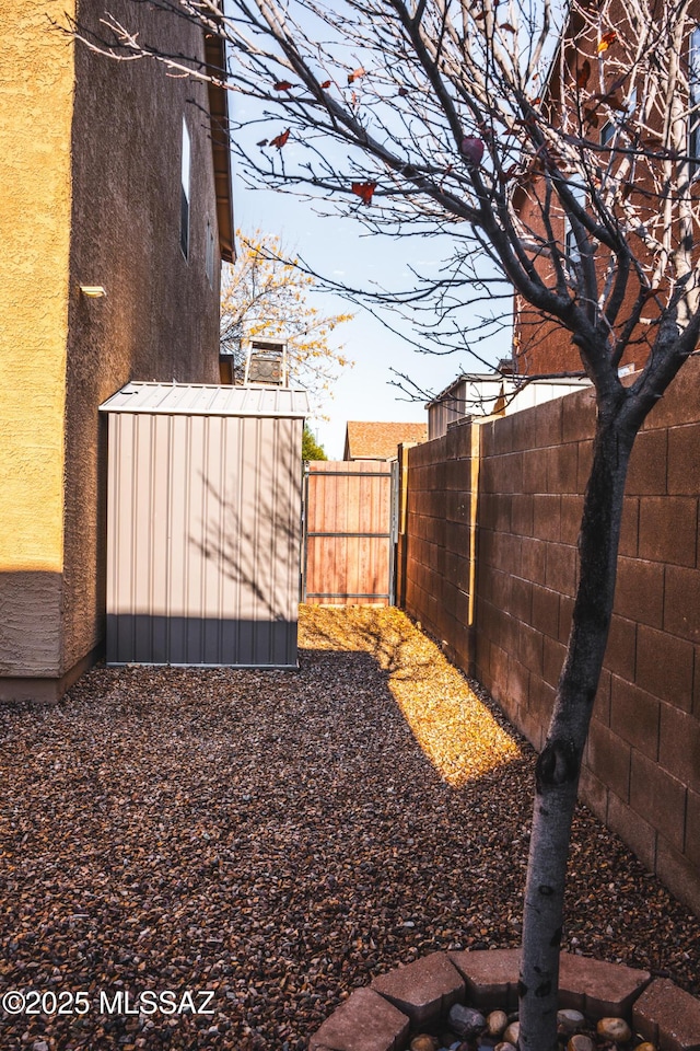 view of yard featuring a storage unit, an outdoor structure, and a fenced backyard