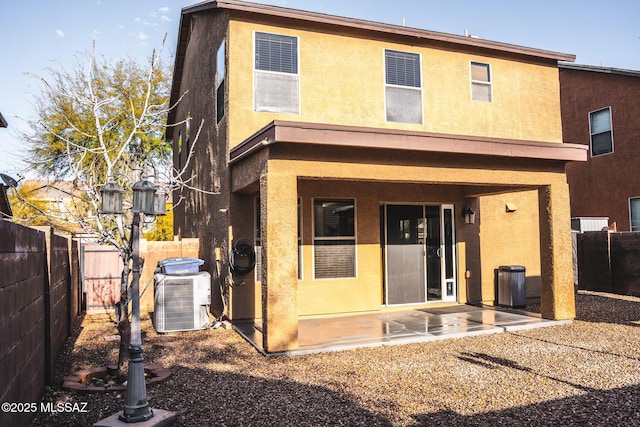 back of house with a patio area, central AC, and stucco siding