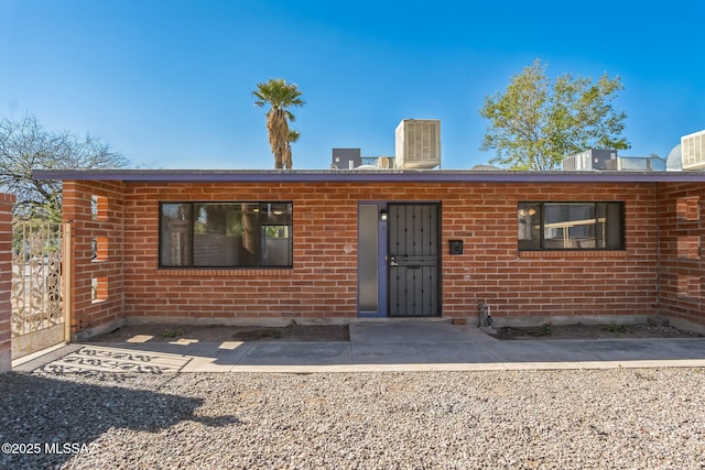 view of front of home featuring brick siding and cooling unit