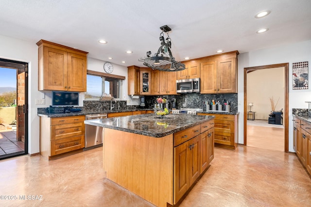 kitchen with stainless steel appliances, brown cabinetry, plenty of natural light, and tasteful backsplash