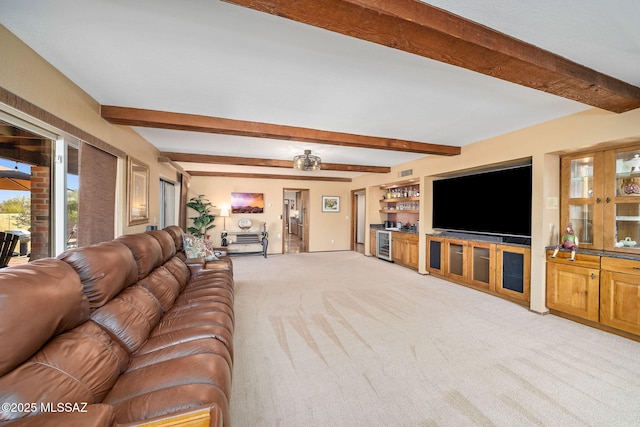 living area with light carpet, visible vents, bar area, and beam ceiling