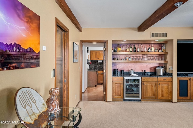 bar with beverage cooler, visible vents, light colored carpet, beamed ceiling, and wet bar