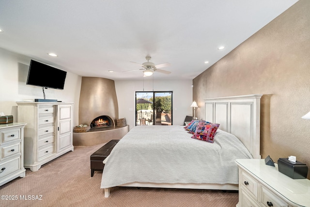 bedroom featuring ceiling fan, recessed lighting, light colored carpet, a fireplace, and access to outside