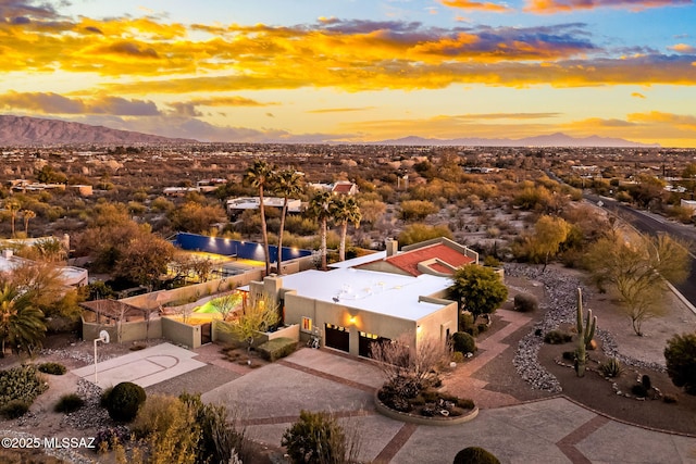 aerial view at dusk featuring a mountain view