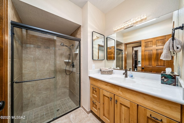 bathroom featuring a stall shower, vanity, and tile patterned floors