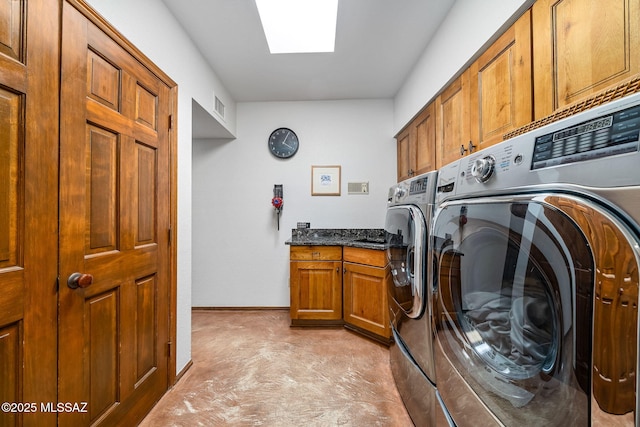 laundry room with a skylight, visible vents, baseboards, cabinet space, and washing machine and clothes dryer