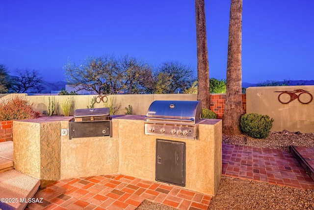 view of patio / terrace featuring exterior kitchen, fence, and grilling area