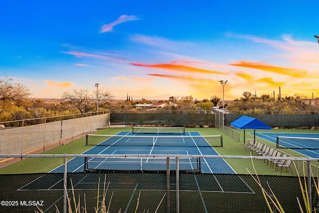 view of tennis court featuring fence