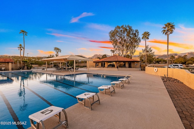 pool featuring a patio area, fence, a gazebo, and a mountain view