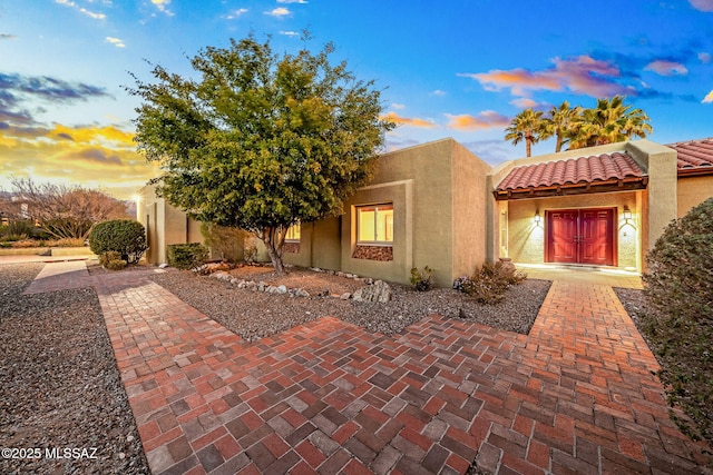 view of front of house with a tiled roof and stucco siding