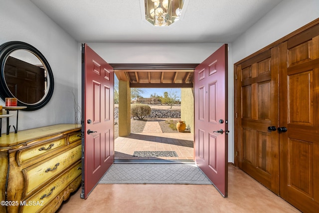 entryway with a chandelier and light colored carpet