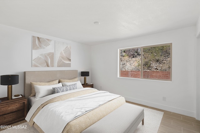 bedroom with light wood-style flooring and baseboards