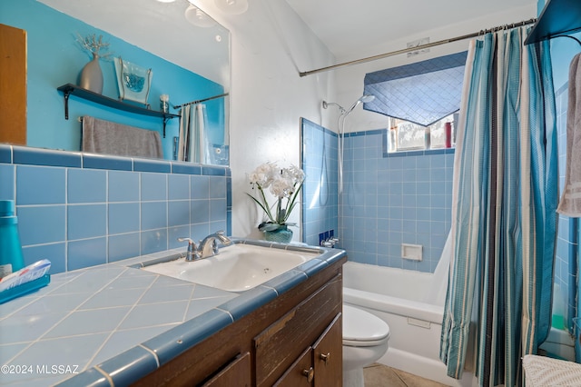 bathroom featuring tile walls, toilet, shower / bath combo with shower curtain, vanity, and tile patterned flooring