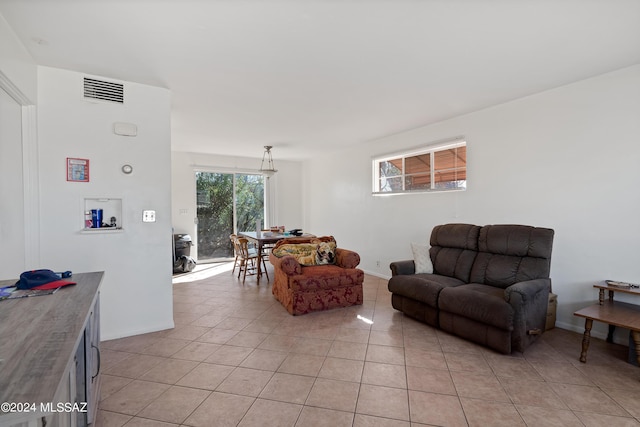 living room featuring baseboards, visible vents, and light tile patterned flooring