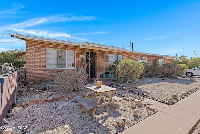 single story home with fence and brick siding