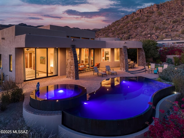 view of pool featuring an in ground hot tub, an infinity pool, and a patio