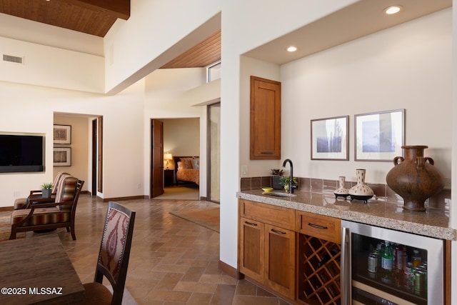 bar featuring visible vents, a sink, recessed lighting, wine cooler, and baseboards