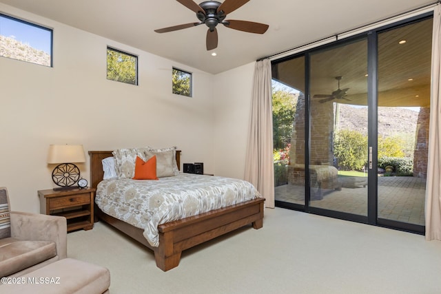 bedroom featuring a wall of windows, access to exterior, multiple windows, and carpet flooring