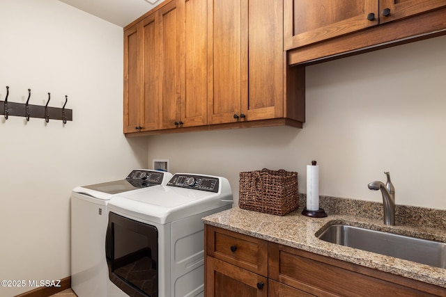 washroom featuring cabinet space, separate washer and dryer, and a sink