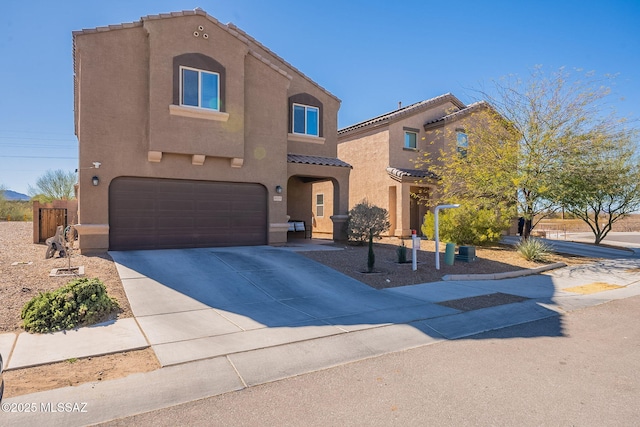 view of front of home featuring a garage, concrete driveway, a tile roof, and stucco siding