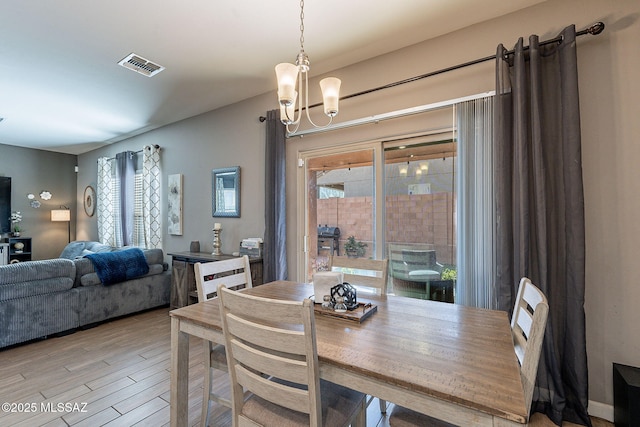 dining area with a notable chandelier, visible vents, and light wood-style floors