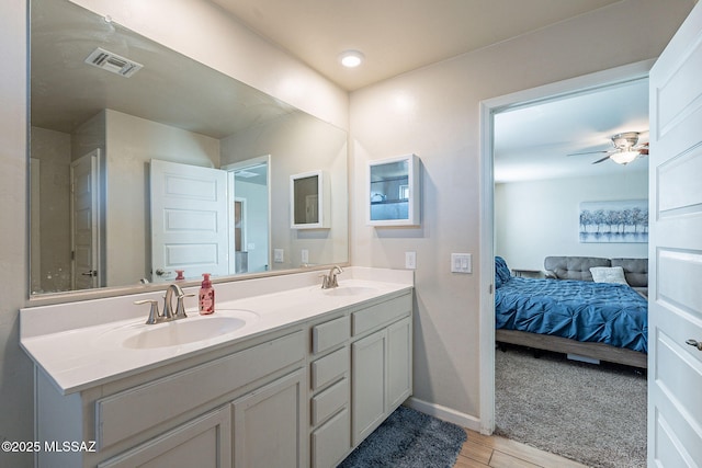 bathroom with double vanity, visible vents, a sink, and ensuite bathroom