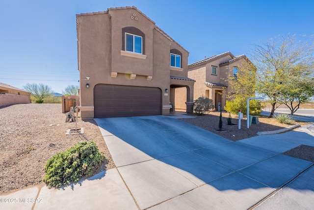 view of front of property with a garage, driveway, a tiled roof, and stucco siding